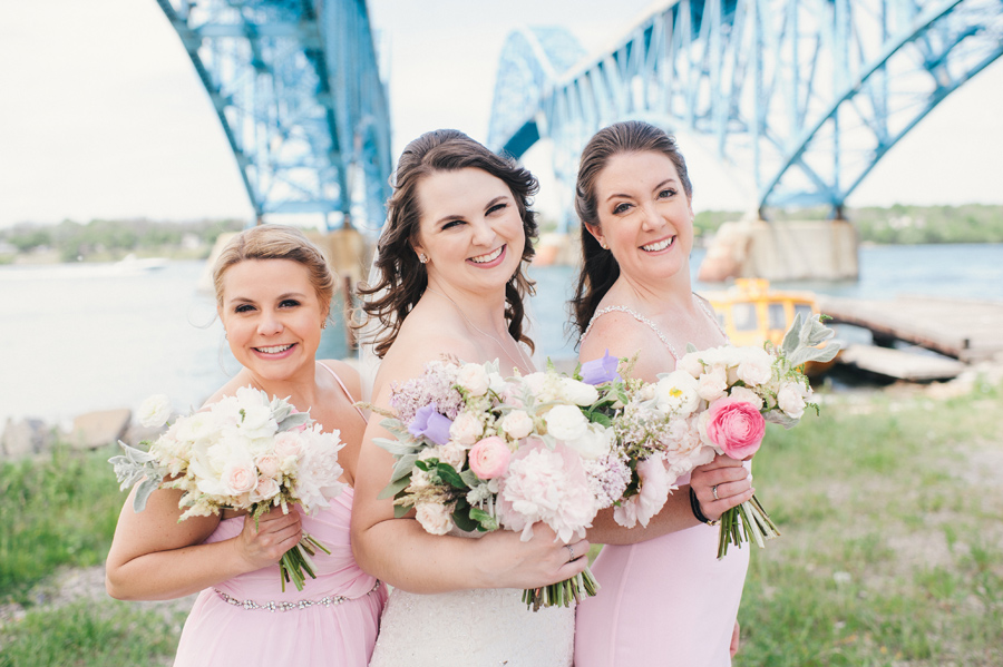 bride and bridesmaids smiling with their bouquets