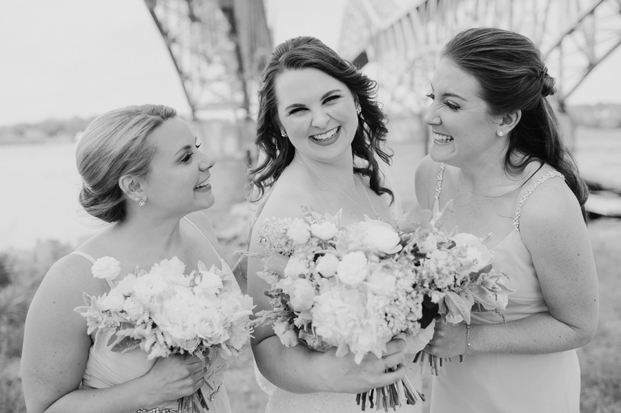 black and white of bride with bridesmaids smiling at each other