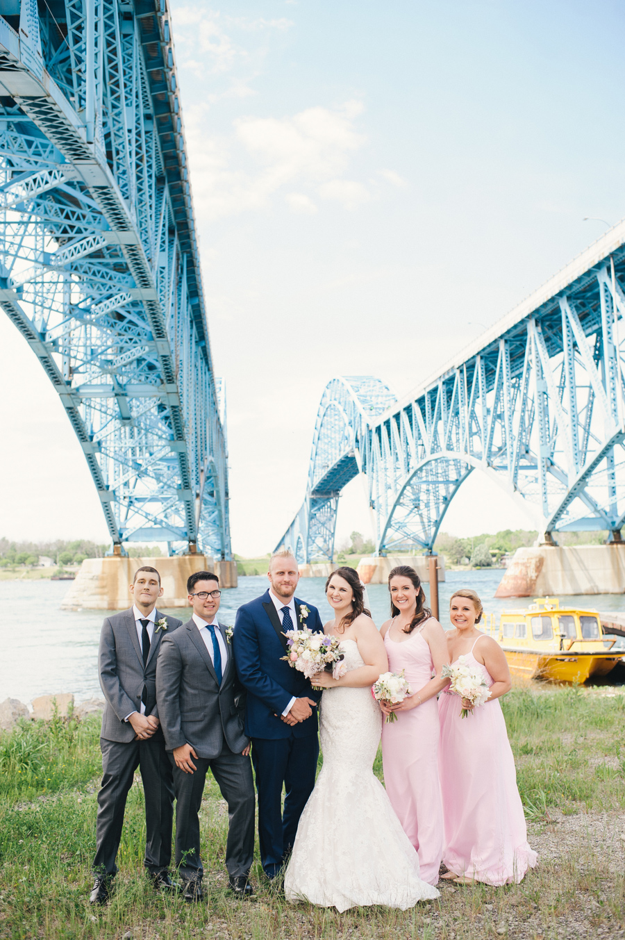 wedding party lined up under the grand island bridge