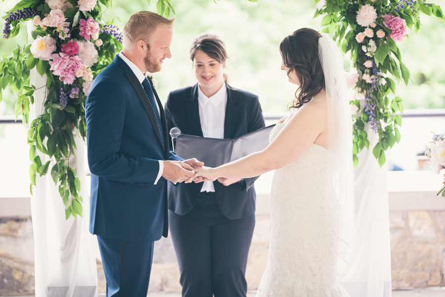 groom placing the wedding band on the bride's finger