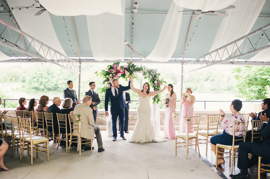 bride and groom celebrating as they walk up the aisle