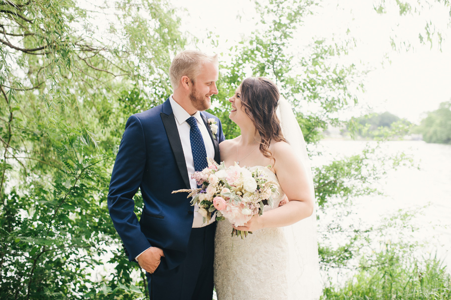 bride and groom laughing together next to hoyt lake