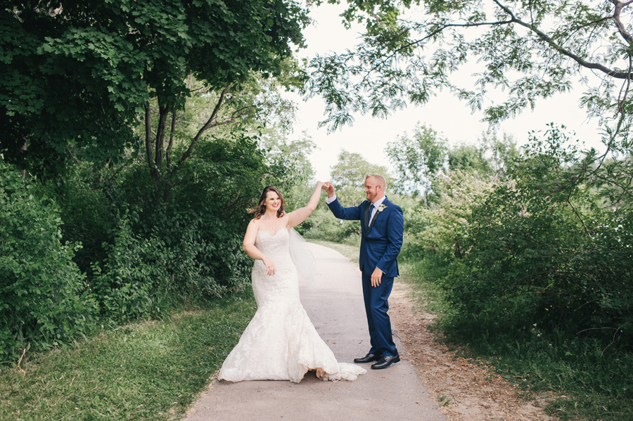 bride and groom dancing in the park