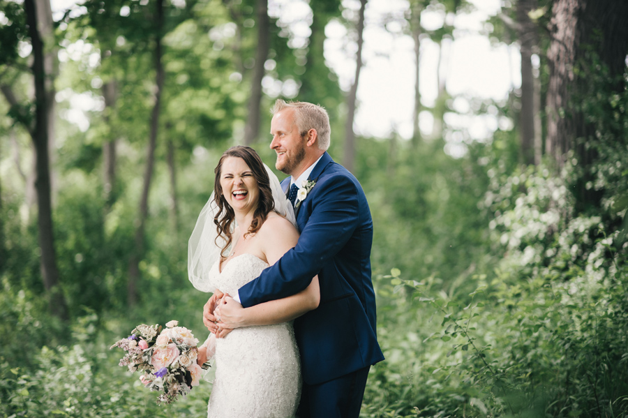 bride laughing while groom hugs her