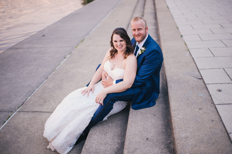 bride and groom sitting on steps near hoyt lake