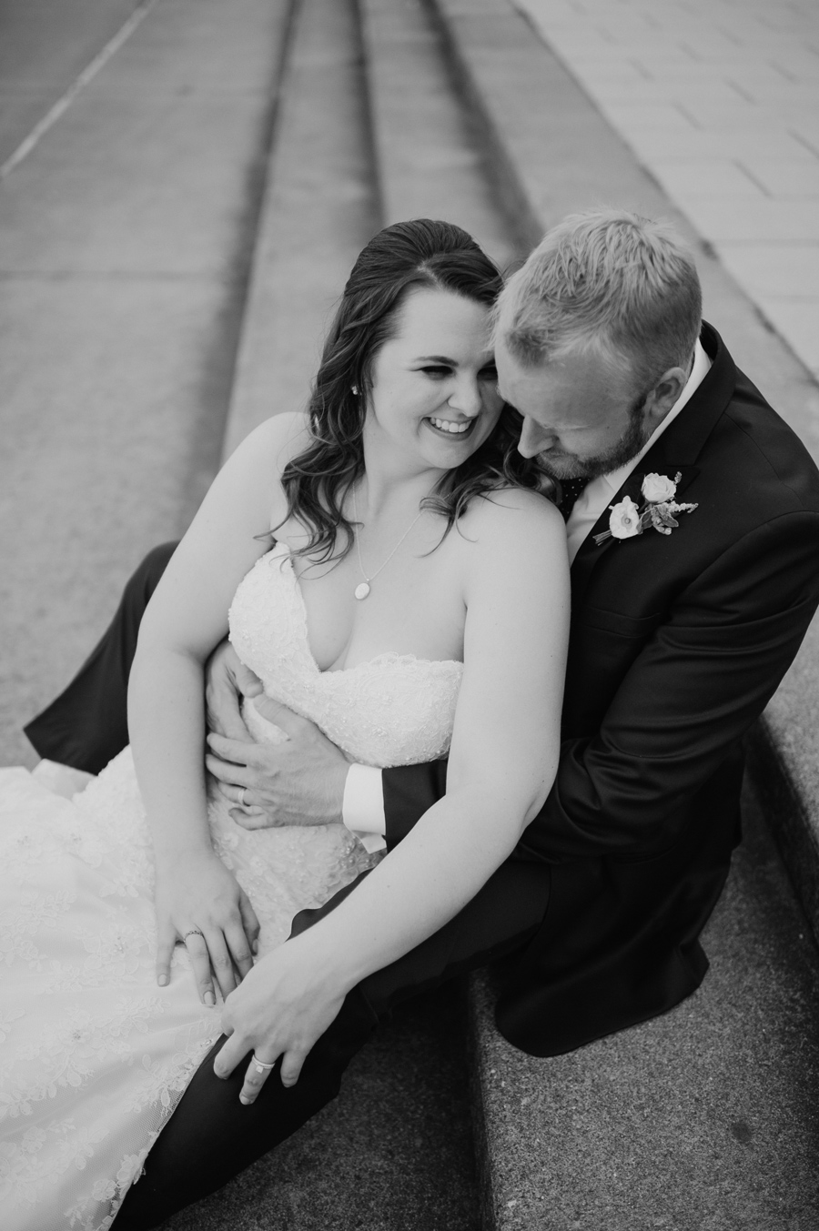 black and white portrait of bride and groom on steps outside