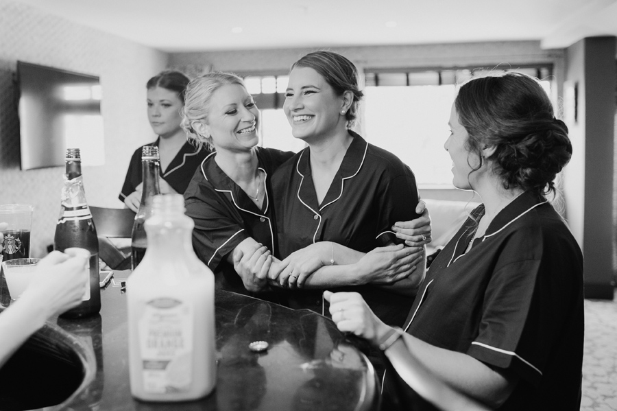 black and white of bride enjoying the morning with bridesmaids in matching pajamas