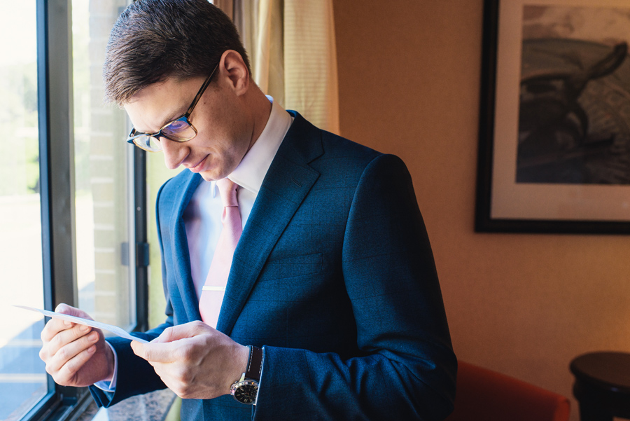 groom reading a card from his soon to be wife on wedding morning