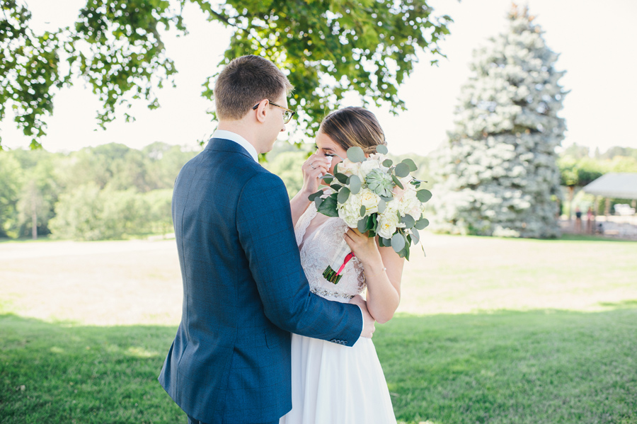 bride wiping away tears during the first look with her groom