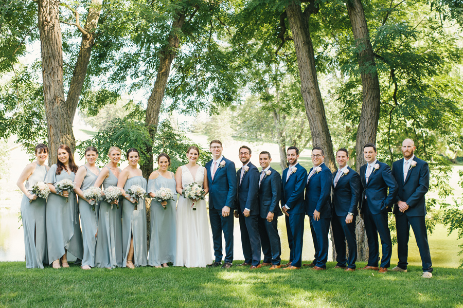 full length shot of the entire 15 person wedding party wearing shades of robins egg and navy blue