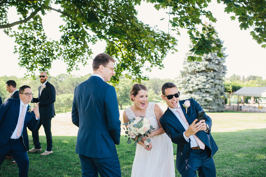 bride taking a selfie with a groomsman