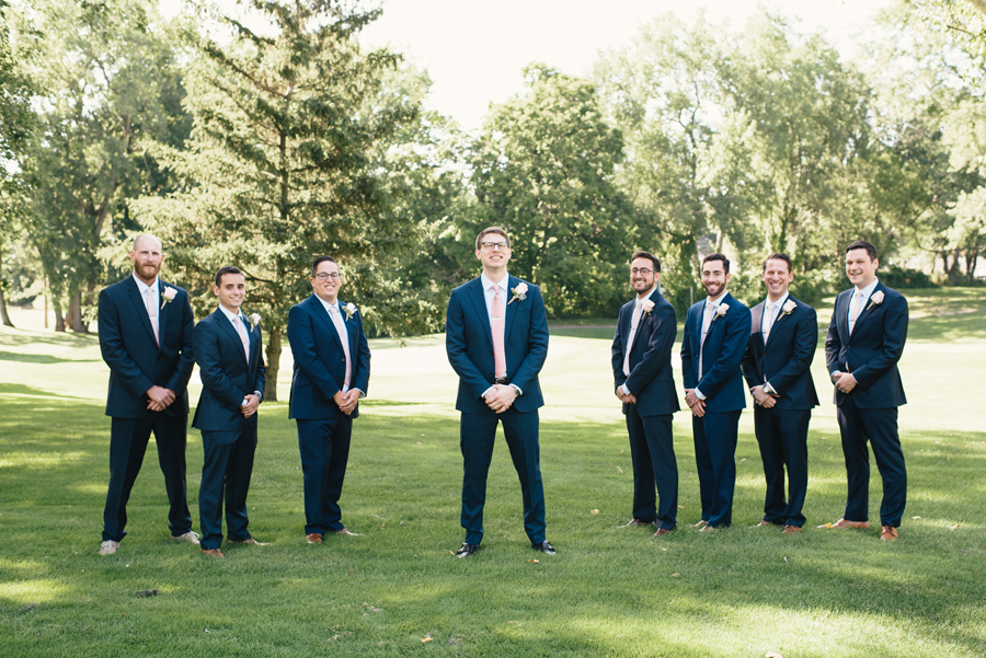 groom and groomsmen posing for the camera on a golf course