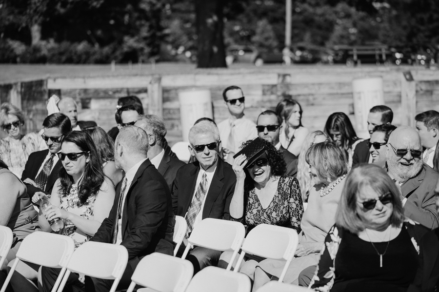 black and white of wedding guests shielding their eyes from the sun