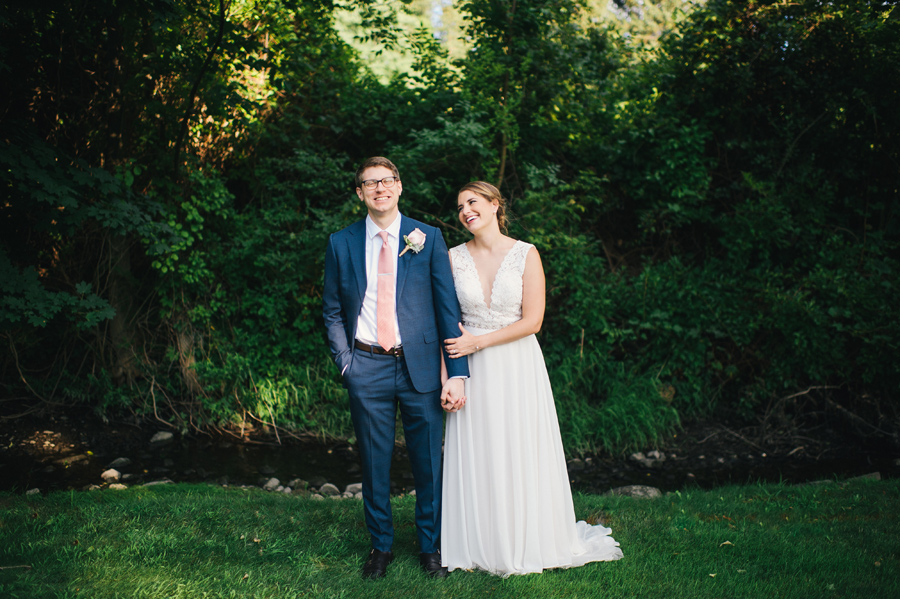 bride lovingly looking at her groom while holding hands in a wooded area