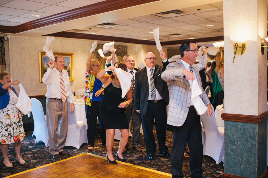 guests waving their dinner napkins in the air at the wedding reception