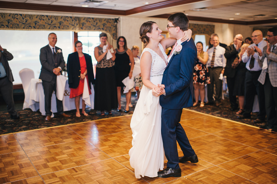 guests watching and clapping during bride and groom's first dance