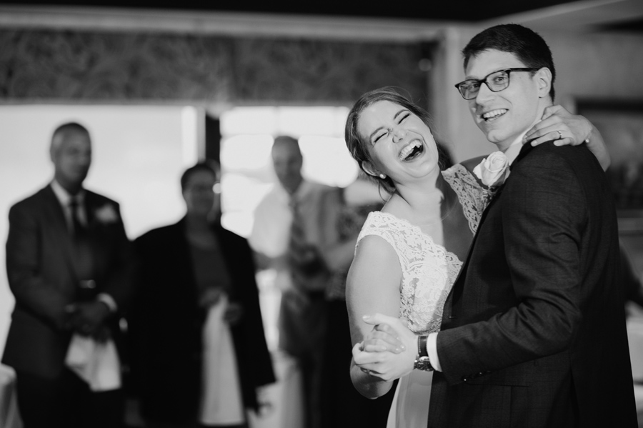 black and white close up of bride laughing during the first dance