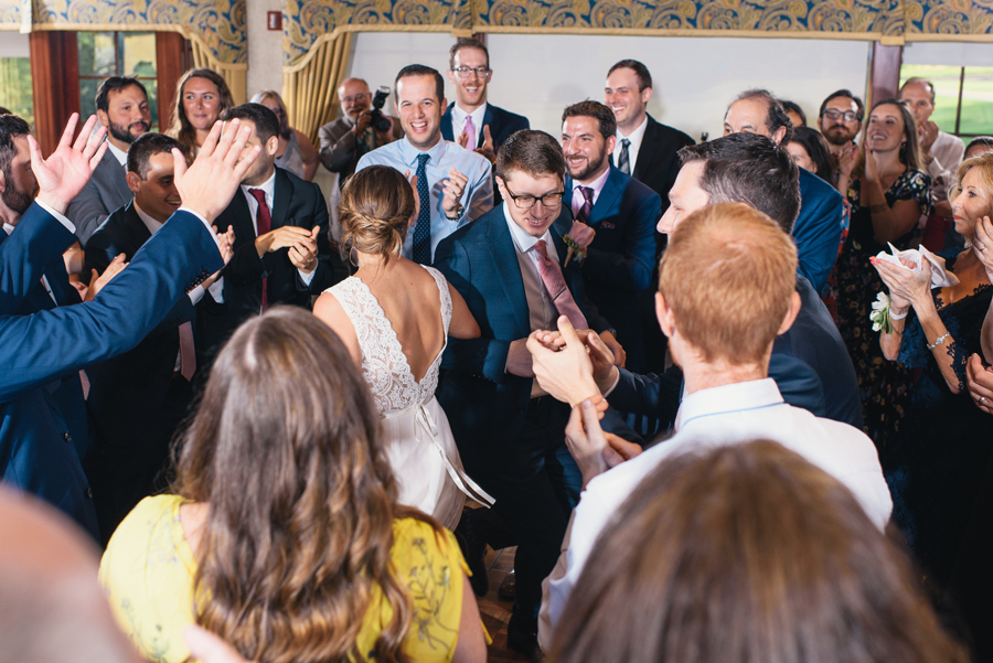 bride and groom dancing the hora in the center of all their wedding guests 