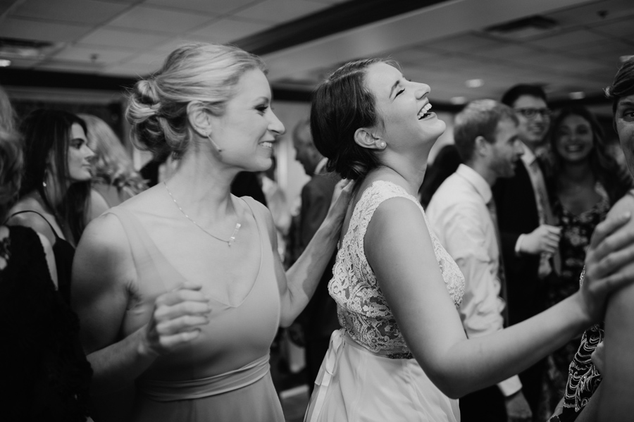 bride and bridesmaid laughing and dancing during the hora