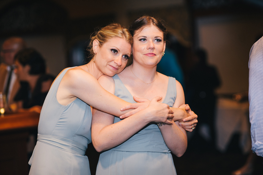 bridesmaids embracing and watching the father daughter dance with sentimental looks