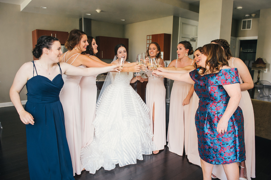 bride and bridal party doing a champagne toast cheers