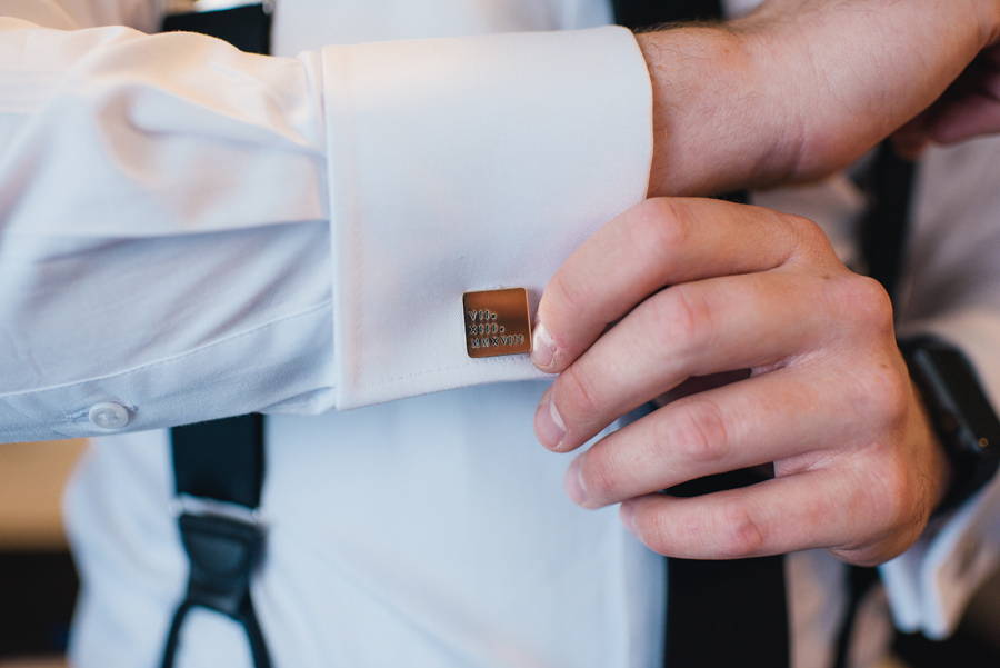 close up shot of the groom's custom made cuff links with the wedding day in roman numerals