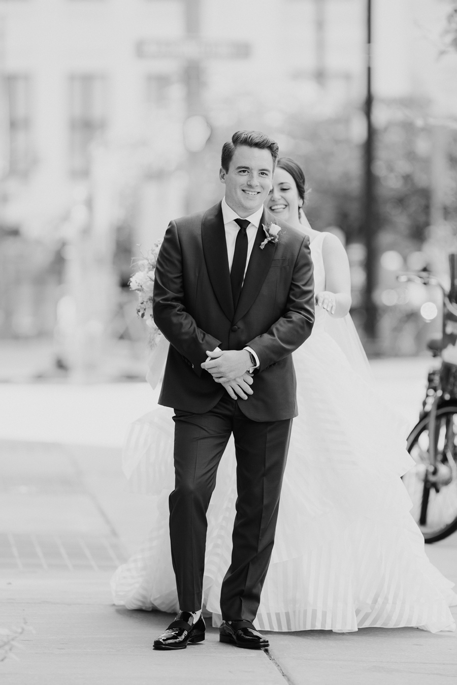 black and white of the bride coming up behind the groom for their first look