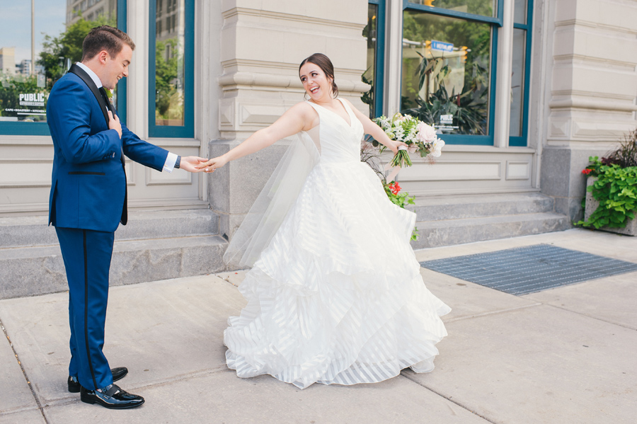 bride showing off her dress to the groom for the first time