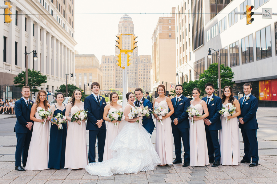 bridal party lined up on the street and smiling at the camera