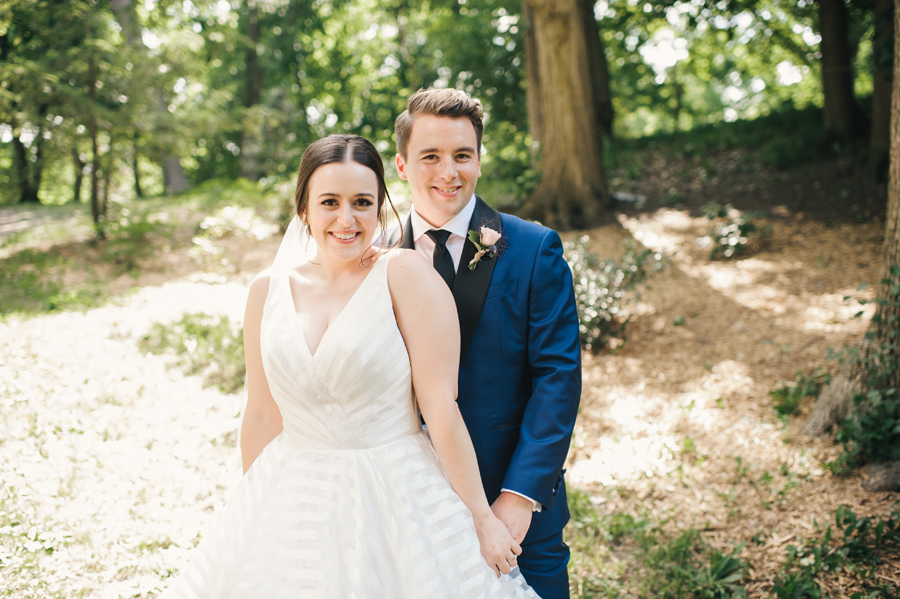 bride and groom holding hands and smiling at the camera