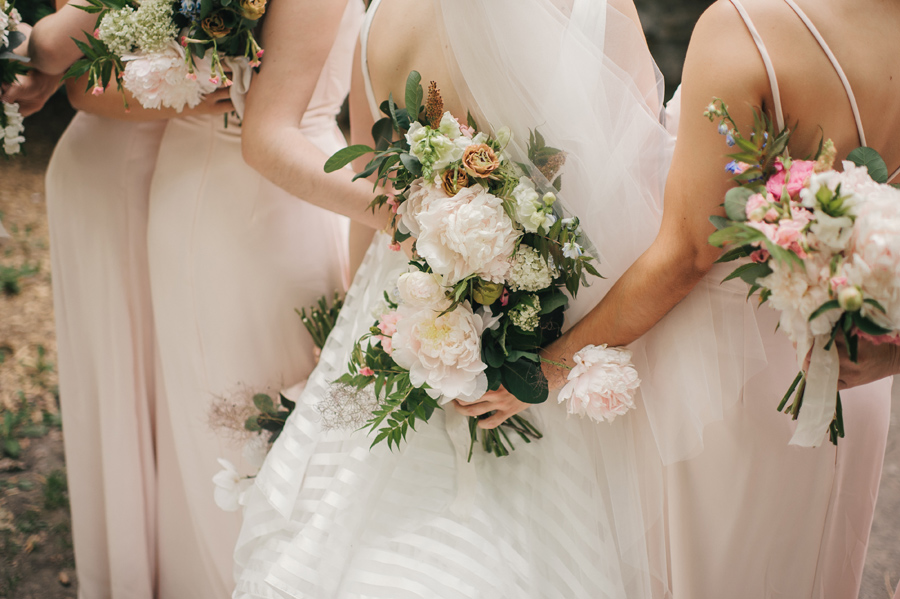 detail shots of bouquets of blush, pink and white being held behind the backs of the bridal party