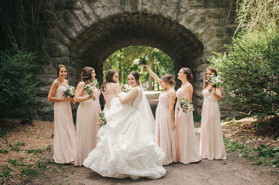 bride having fun with her dress and her bridesmaids