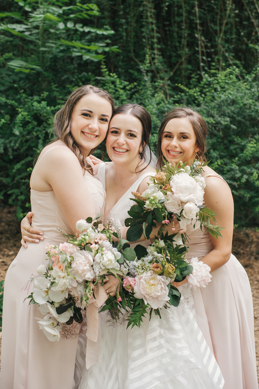 bride and her sisters smiling for the camera