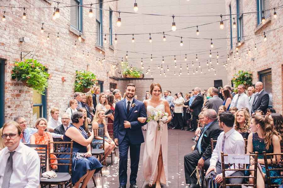 bridesmaid and groomsman walking down the aisle together and smiling