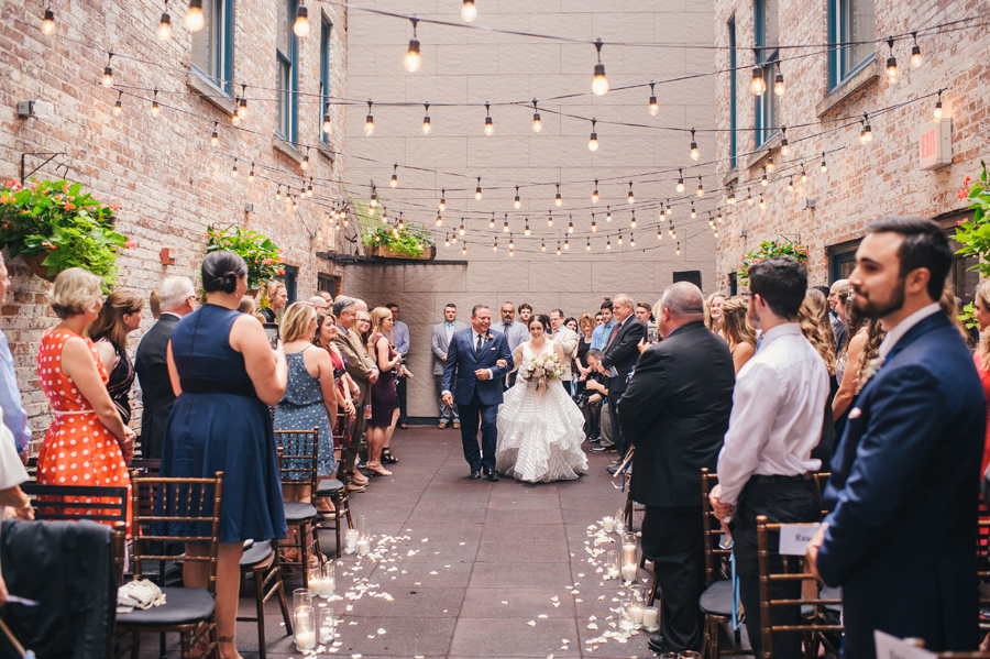 bride and her father walking down the aisle at the courtyard ceremony