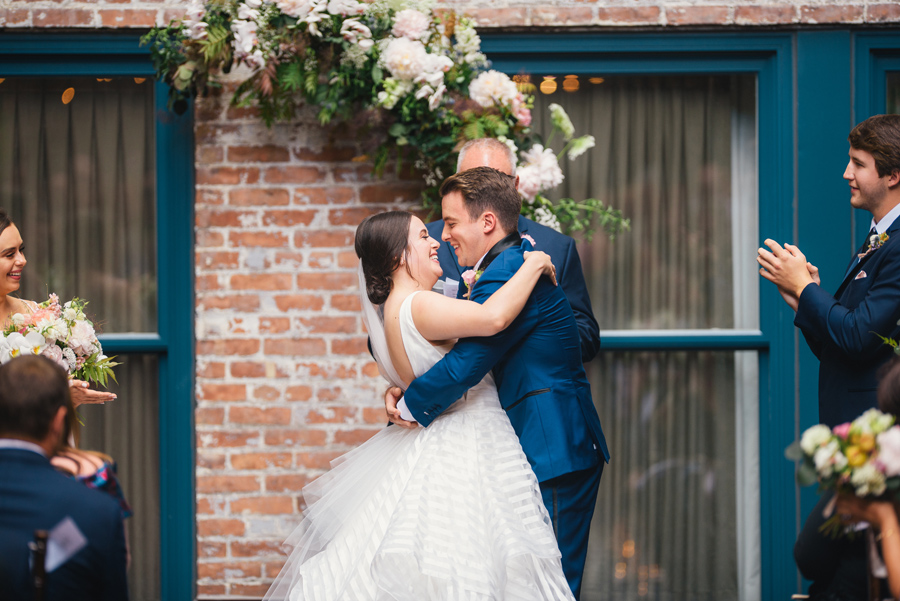 bride and groom smiling with their arms around each other at the end of the ceremony