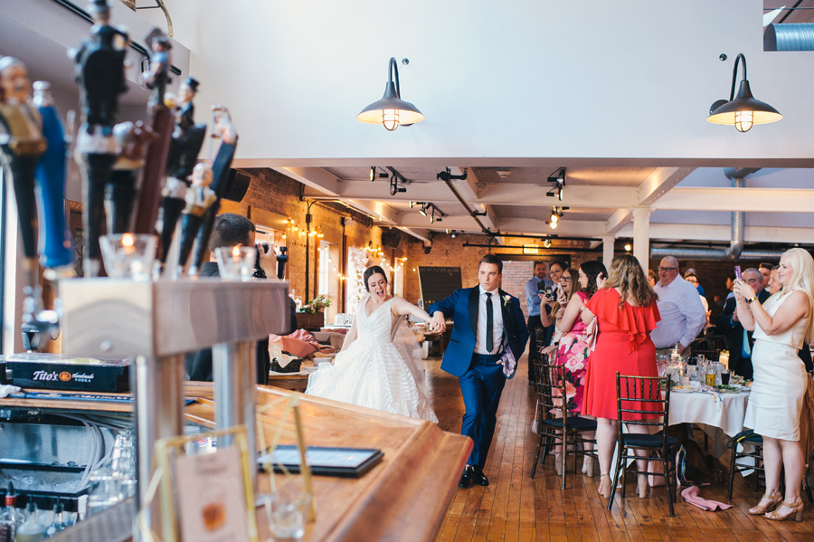 bride and groom entering the reception hand in hand