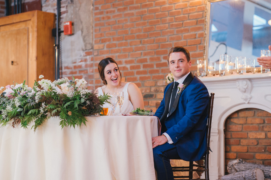 bride and groom looking on during the best man's speech