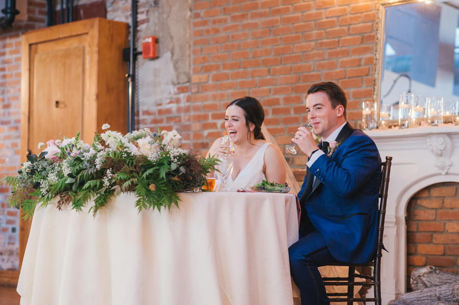 bride and groom laughing during a champagne toast at the reception