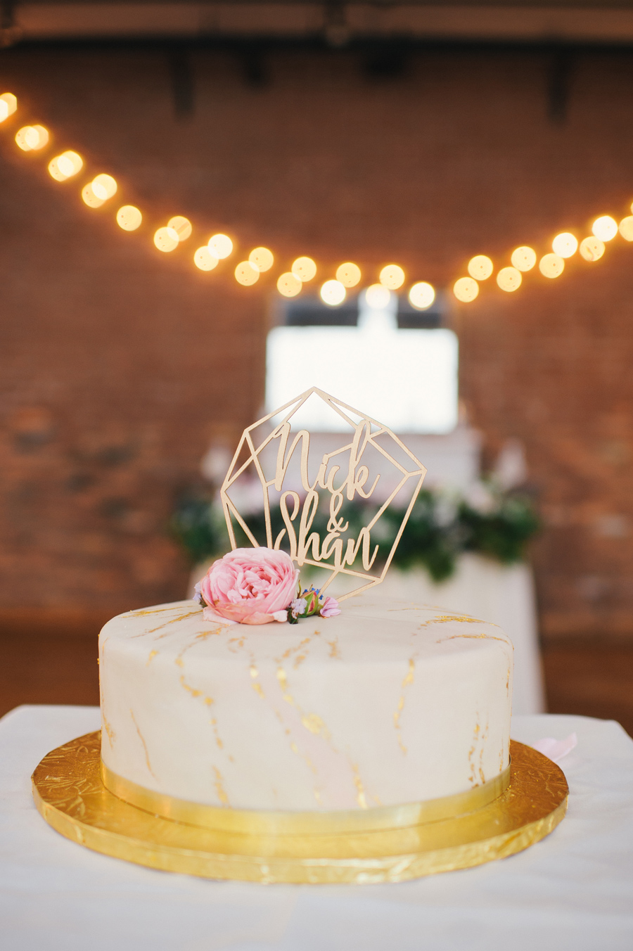 detail shot of the single tier round wedding cake with ivory fondant and gold painted marbling detail