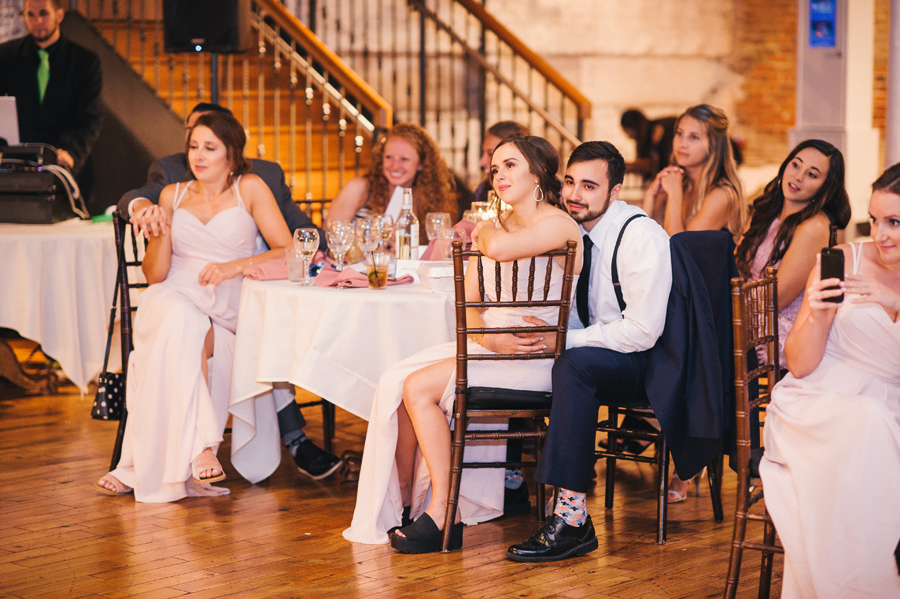 bridal party seated and smiling while watching the first dance