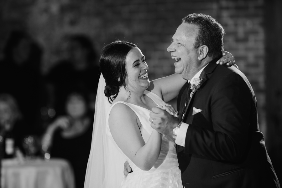 black and white of the bride and her father laughing together during their dance