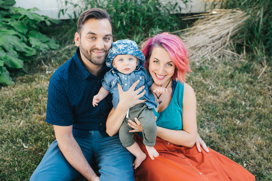 father, mother and baby outside smiling at camera