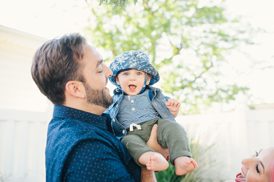 father holding young son who is smiling at the camera