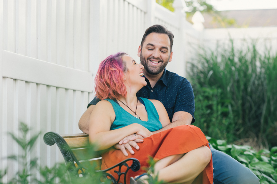 husband and wife sitting together on bench laughing