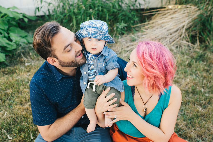 parents smiling at their young son as he looks at camera