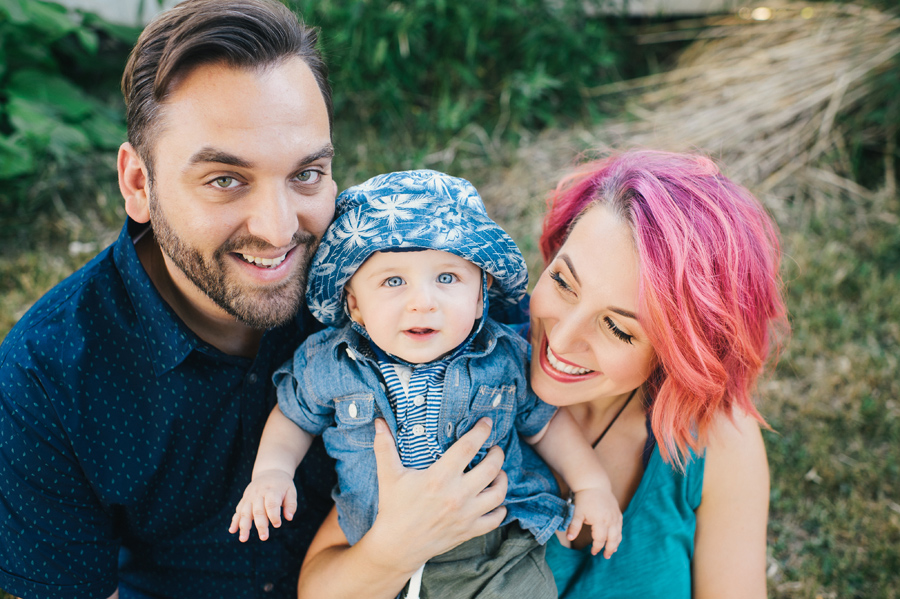 close up of parents holding baby boy who is smiling at camera