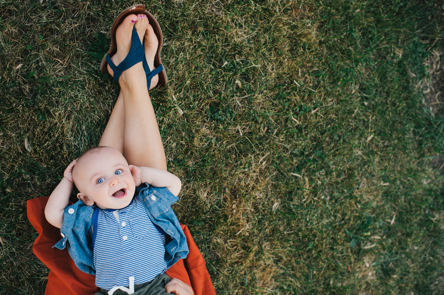 birds eye view of baby laying on his mother's leg