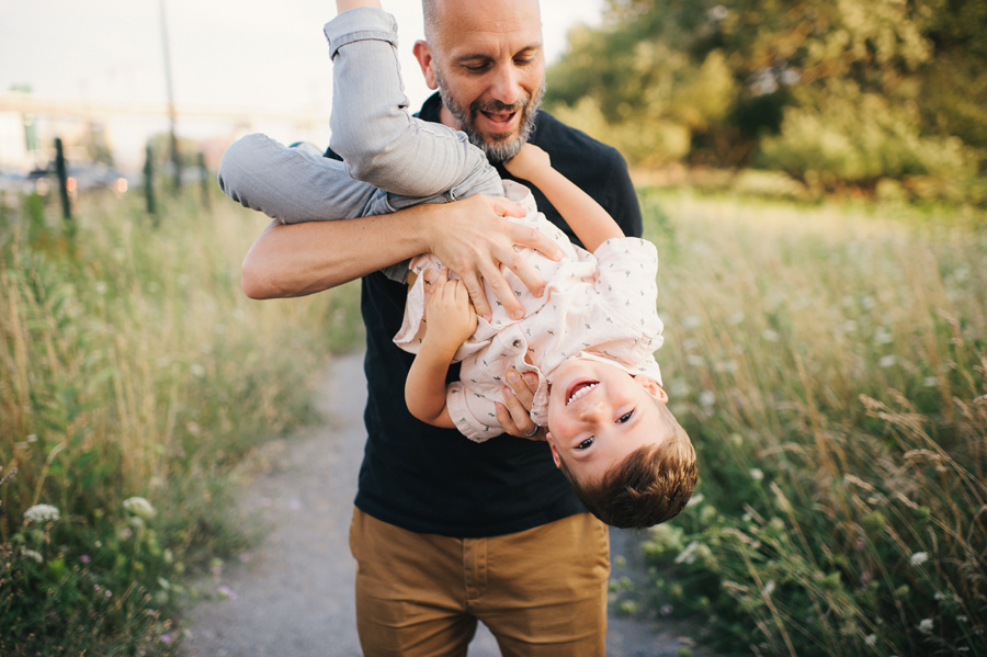 dad holding son upside down and laughing