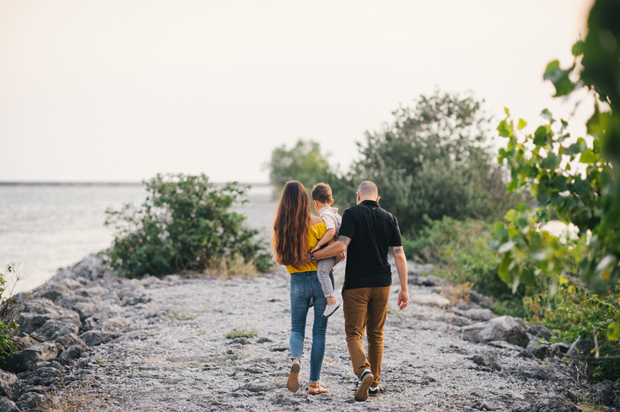 family walking away from camera while mom carries son